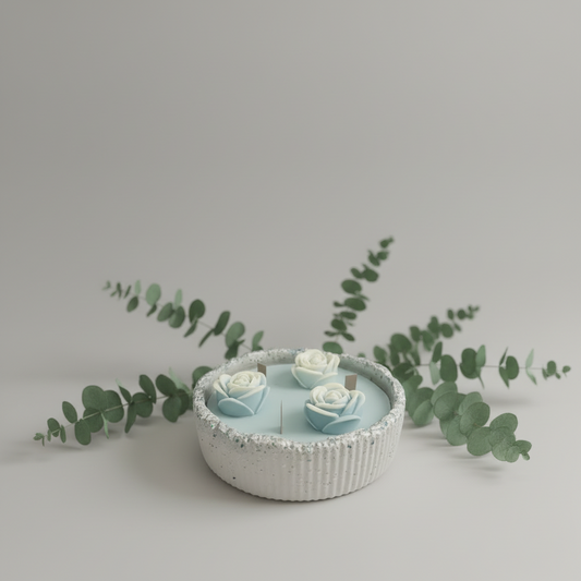 Handgemachte Kerze in Schale mit blauen Rosen, dekorativ auf orangefarbenem Stoff drapiert