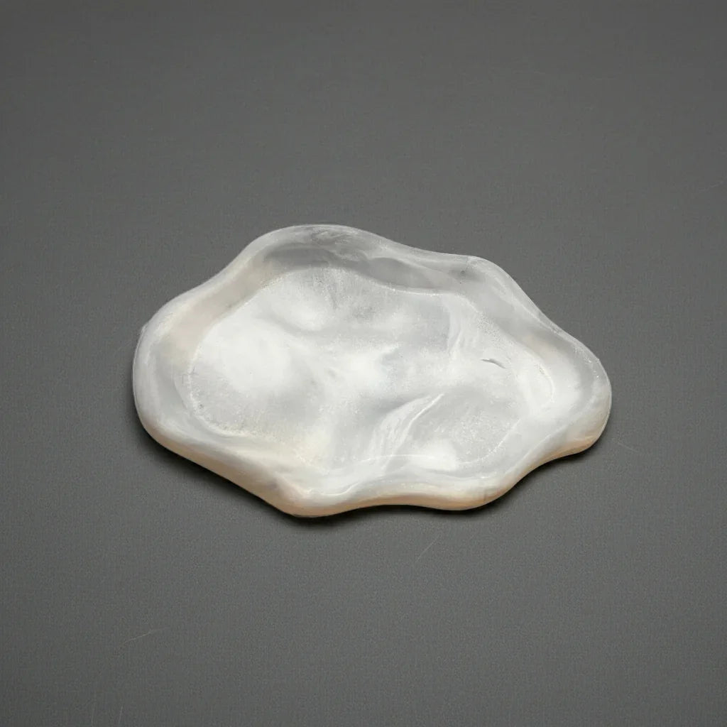 Handgefertigtes, weißes Kerzenschälchen aus Marmoroptik auf grauem Untergrund