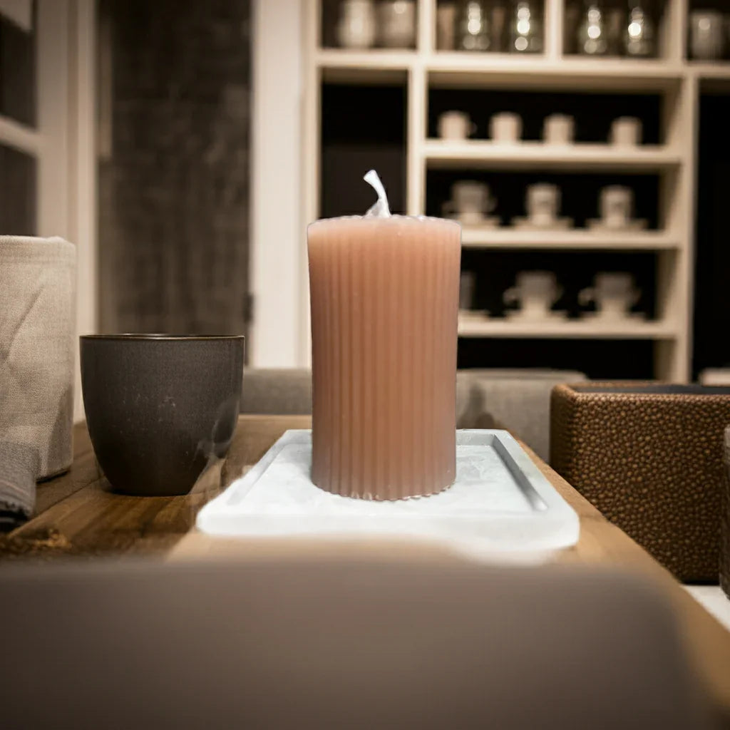 Handgemachte gerippte Kerze auf Tablett, gemütliche Wohnatmosphäre, nachhaltige Dekoration