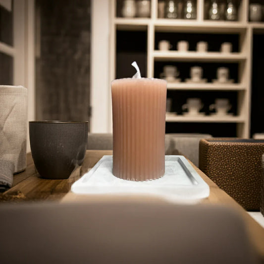 Handgemachte gerippte Kerze auf Tablett, gemütliche Wohnatmosphäre, nachhaltige Dekoration