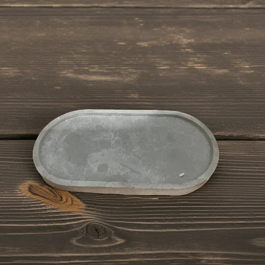 Ovale Kerzenschale aus Beton auf dunklem Holz, minimalistisch, handgemacht, Dekoration