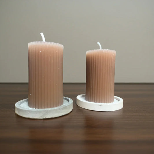 Zwei handgemachte braune Kerzen auf weißen Untersetzern, Tischdeko, nachhaltiges Licht