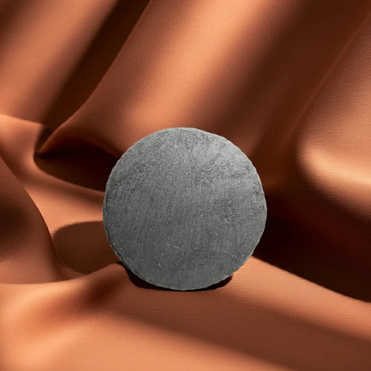 Runde schwarze Schieferplatte auf braunem Stoff, hochwertiges Kerzenzubehör