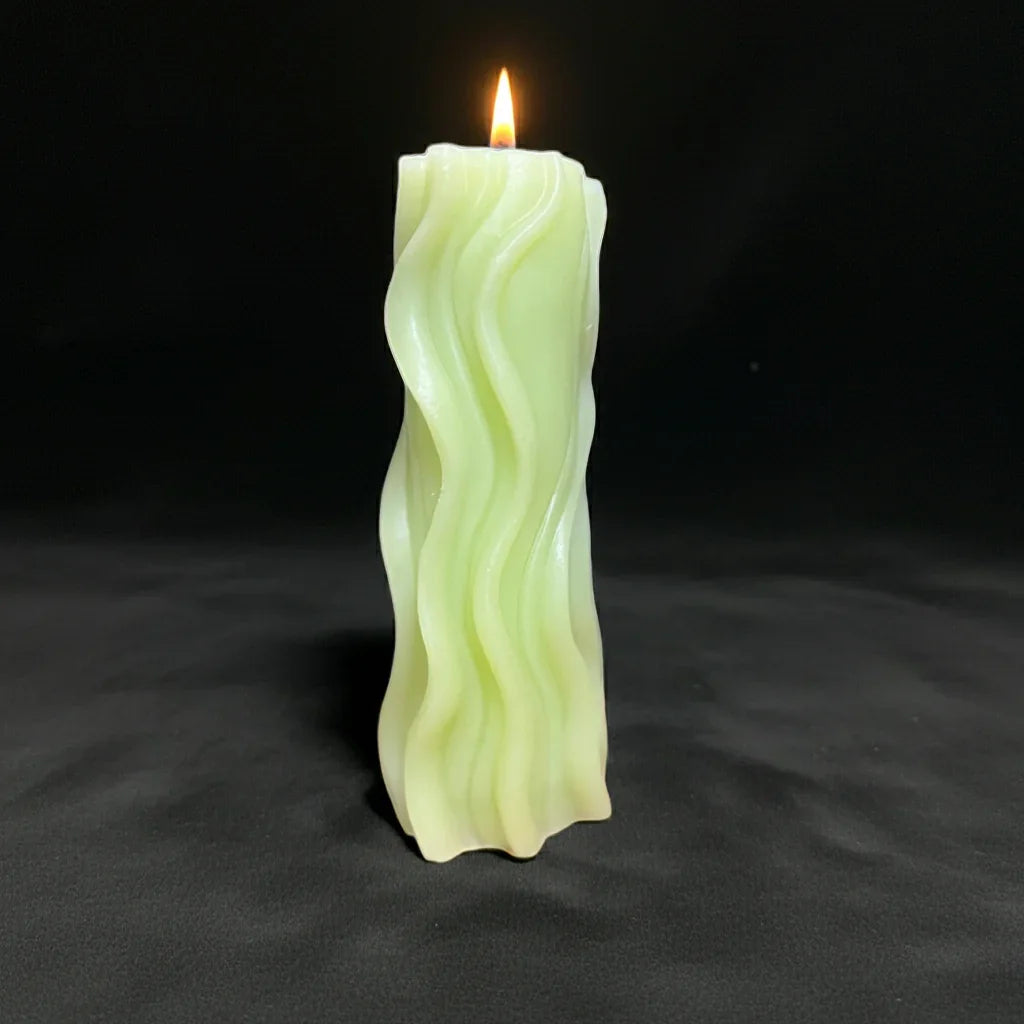 Handgemachte Kerze mit welligem Design, leuchtend, auf schwarzem Hintergrund