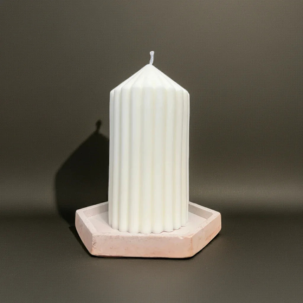 Handgemachte weiße Kerze mit Rillenstruktur auf sechseckigem Untersetzer, schlichtes Design