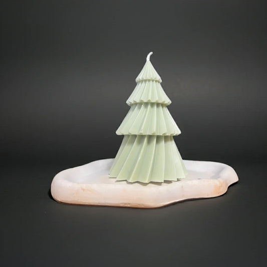 Handgemachte Kerze in Tannenbaumform auf Marmorplatte, dekorative Geschenkidee