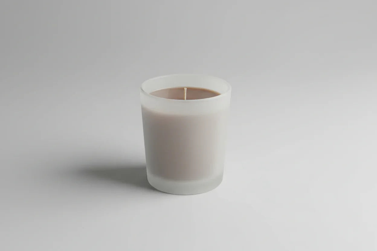 Handgemachte Duftkerze im matten Glas, minimalistisch auf hellem Hintergrund
