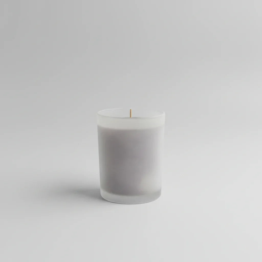Handgemachte Kerze in mattem Glas, minimalistisch auf hellem Hintergrund, dekorativ