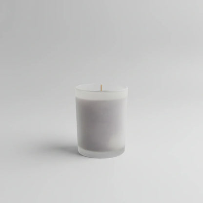 Handgemachte Kerze in mattem Glas, minimalistisch auf hellem Hintergrund, dekorativ